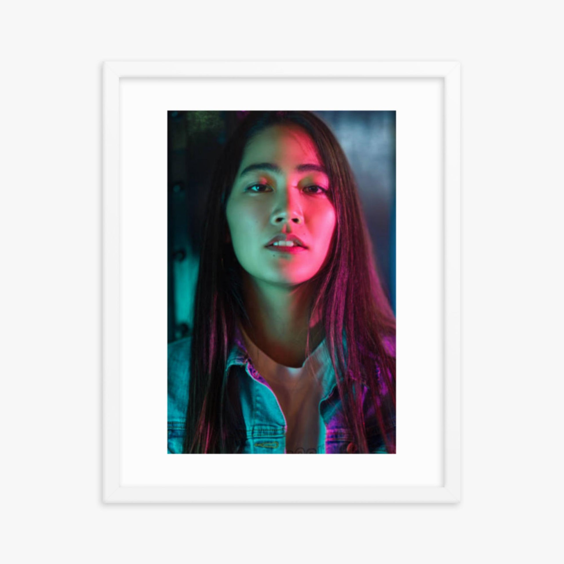 Portrait of young woman lit by colorful neon lights at night 16x20 in Poster With White Frame